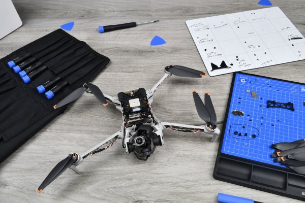 A partially disassembled DJI Mini 3 drone with iFixit tools in the background
