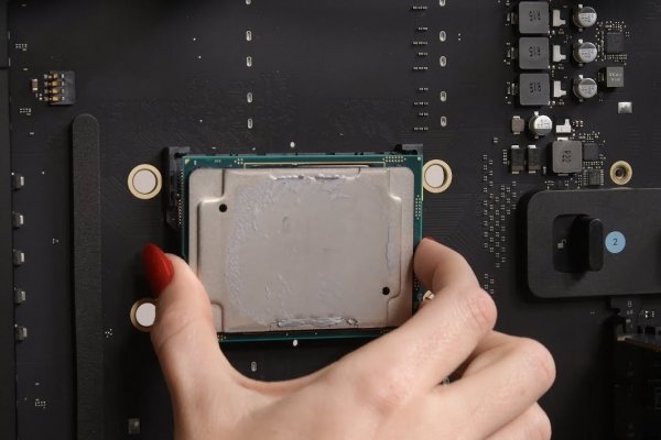 Hand holding a component on the board of a 2019 Mac Pro